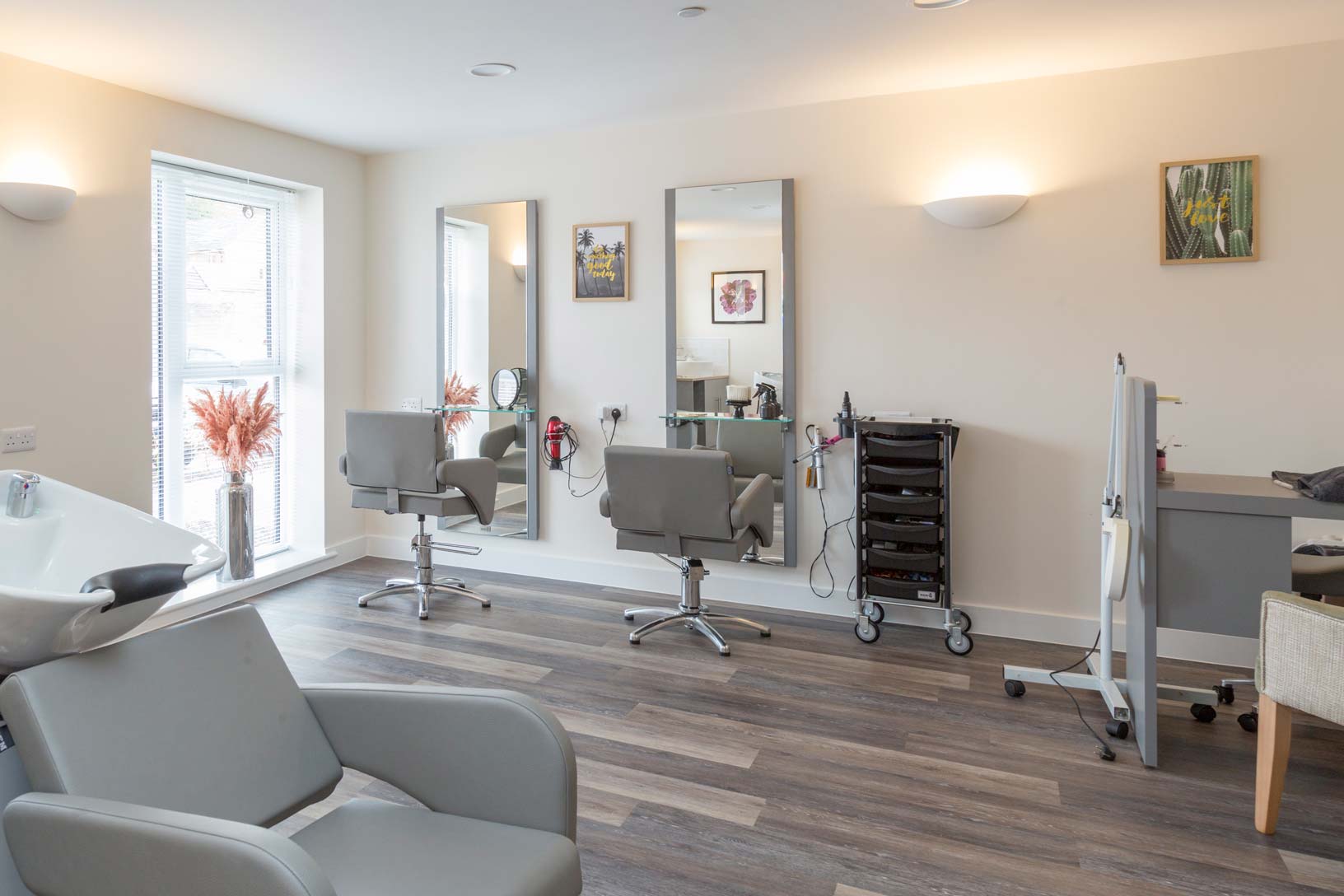 A salon with stylish chairs and a large mirror for customers to admire their new looks. Services available at The Dials.