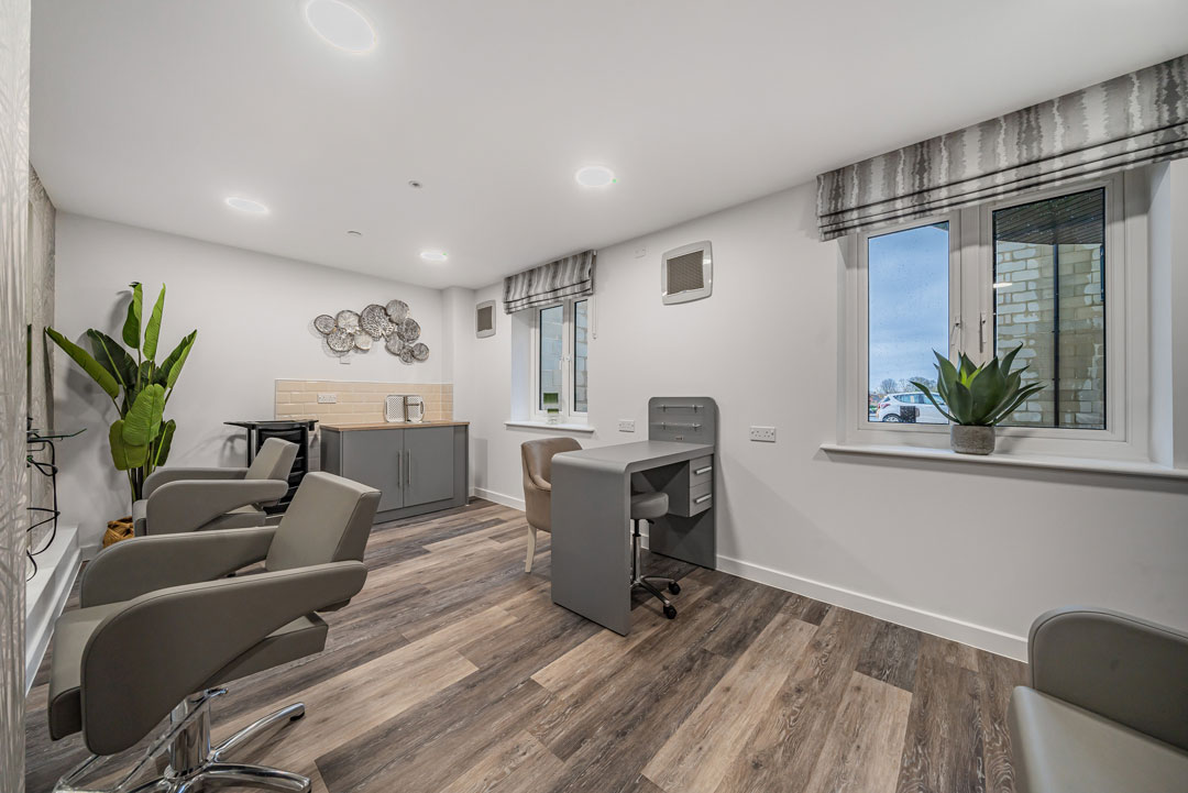 A salon with stylish chairs and a central desk in a spacious room. Available for all our Anchor residents.